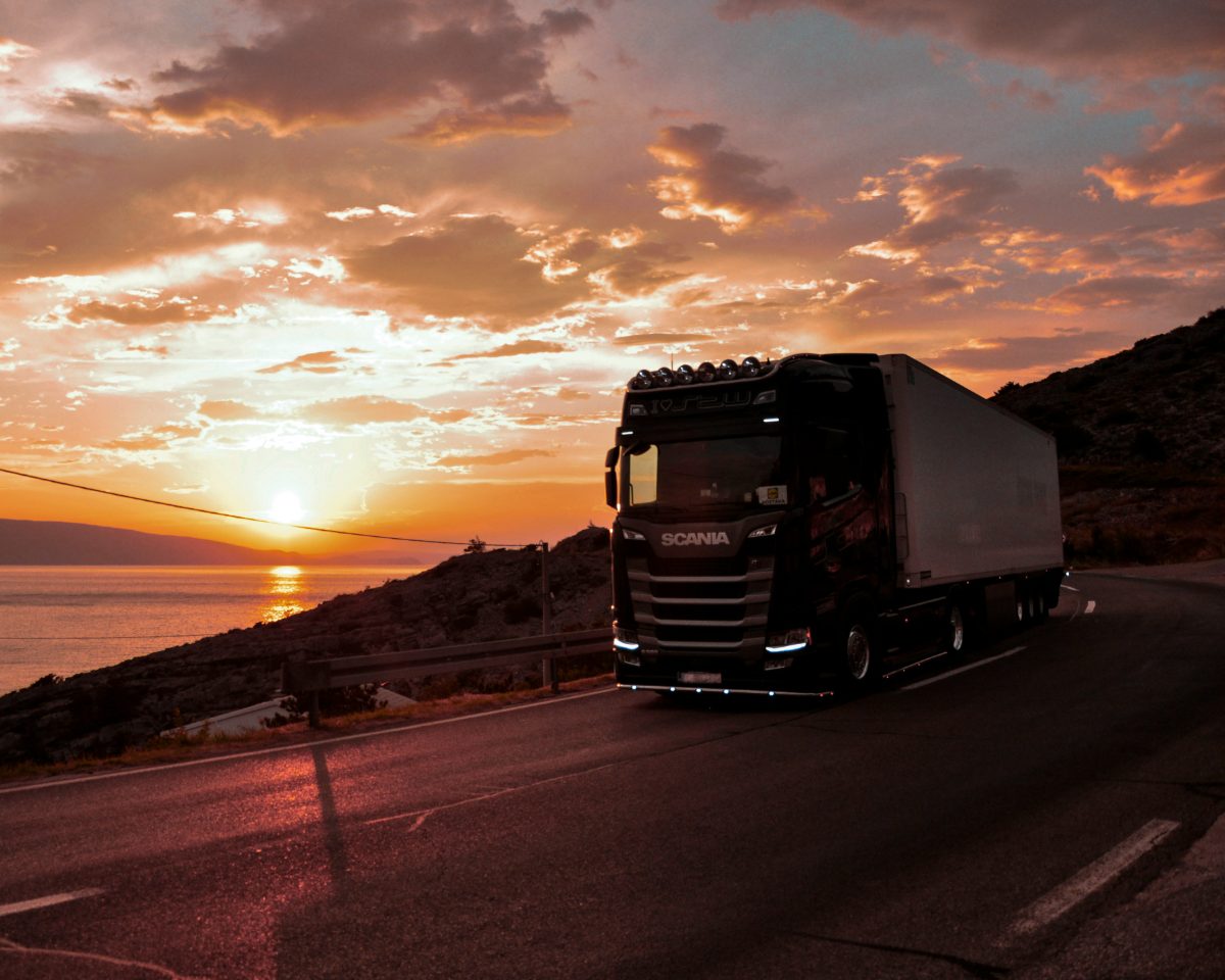 Freight truck on a coastal road at sunset