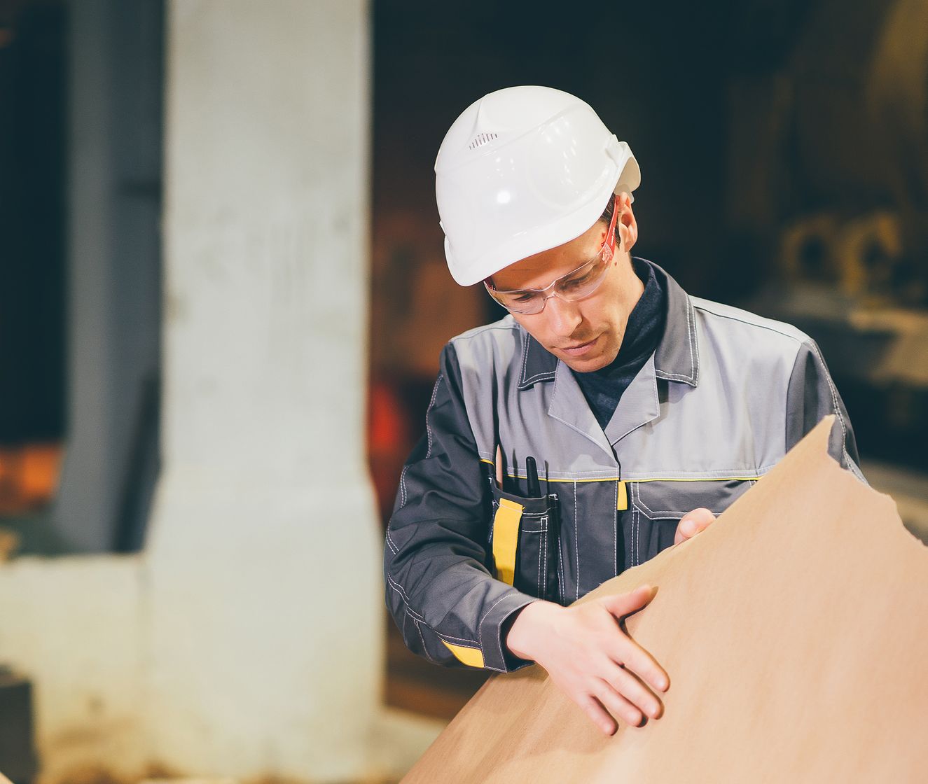 Mill operator inspecting a sheet of kraft paper